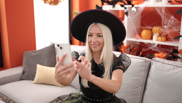 Young blonde woman make selfie by smartphone having halloween party at home