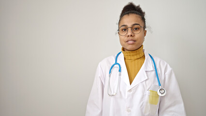 Young african american woman doctor standing with serious expression over isolated white background