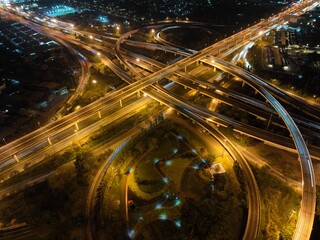 Fototapeta na wymiar Expressway top view, Road traffic an important infrastructure, car traffic transportation above intersection road in city night, aerial view cityscape of advanced innovation, financial technology