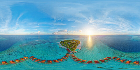 Luxurious overwater villas on Alimatha Island in the Maldives, Vaavu Atoll, at sunset. Aerial...