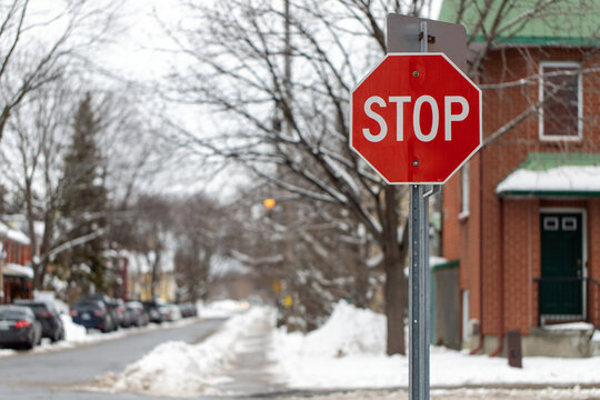 Stop sign in a residential neighborhood at crossroads in winter.