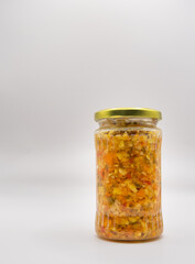 Jar of pickled chopped vegetables preserved for winter. Fermented vegetables concept. Pepper, onion, celery, tomato, carrots.