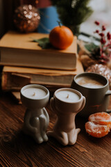 handmade scented candles, coffee, books and tangerines for the New Year. Cozy atmosphere of Christmas at home