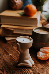 handmade scented candles, coffee, books and tangerines for the New Year. Cozy atmosphere of Christmas at home