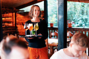 female bar owner serving to a group of customers something to drink