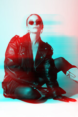 Woman studio portrait with black punk leather jacket, pantyhose, sunglasses. Model without bra...