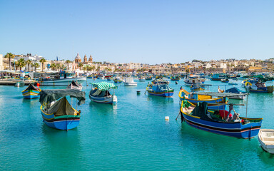 Boats on turquoise sea in bay near Marsaxlokk, Malta