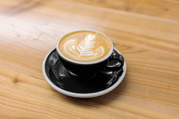 Coffee in a black cup on a wooden table