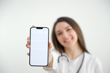 Woman doctor with a smartphone, on a blue background. Place for advertising. Copy paste. healthcare concept. High quality photo