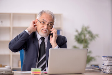 Old male employee working in the office