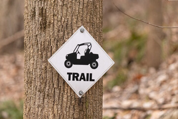 This trail sign is indicating to everyone that this is a ATV trail and that four wheelers can be...