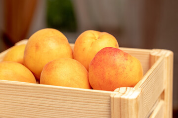 Ripe delicious apricots in a wooden box outdoors