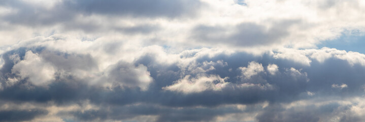 A stormy sky with dark and light clouds illuminated by the sun