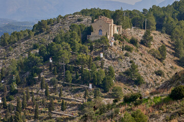 Fototapeta na wymiar Stone house on top of a mountain with a beautiful winding road