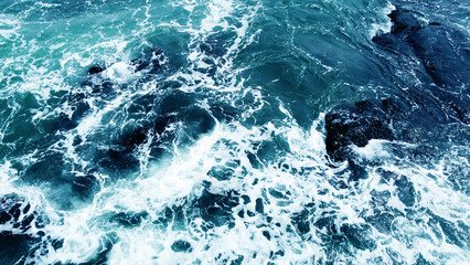 Aerial view of the ocean water surface and waves. Beautiful water background texture for tourism and advertising. Tropical coast
