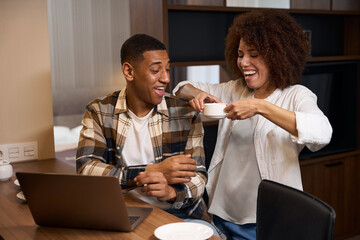 Guy with laptop sits at table in the kitchen area