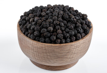 Bowl full of black pepper on a white background,closeup