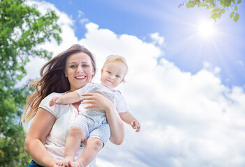 Healthy child (kid) having fun with mother in the sunny summer day. Happy baby (boy) in the casuals clothing. Healthy lifestyle, happy childhood, Mother's Day concept. Copy space.