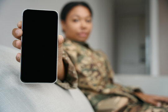 African american female soldier demonstrates the screen of the phone