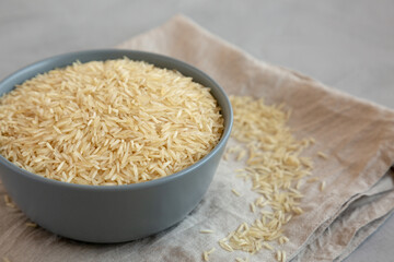 Dry Organic Indian Basmati Rice in a Bowl on a gray background, low angle view. Close-up.
