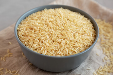 Dry Organic Indian Basmati Rice in a Bowl on a gray background, low angle view. Close-up.