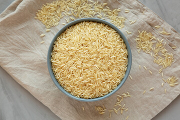 Dry Organic Indian Basmati Rice in a Bowl on a gray background, top view. Flat lay, overhead, from above.