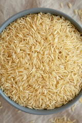 Dry Organic Indian Basmati Rice in a Bowl on a gray background, top view. Flat lay, overhead, from above.