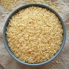 Dry Organic Indian Basmati Rice in a Bowl on a gray background, top view. Flat lay, overhead, from above.