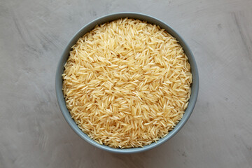 Dry Organic Indian Basmati Rice in a Bowl on a gray background, top view. Flat lay, overhead, from above.