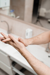 Doctor surgeon is washing hands before surgery in medical clinic. Hygiene. Correct hand washing with soap, gel and water.