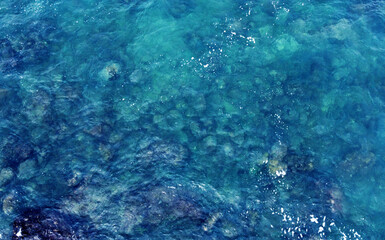 Fototapeta premium Aerial view of the ocean water surface and waves. Beautiful water background texture for tourism and advertising. Tropical coast