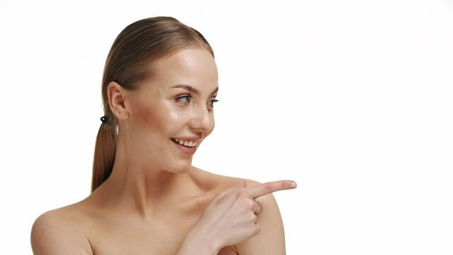 A young blonde girl points her index finger to the side. Shock, Surprise. Concept of people who react emotionally to events