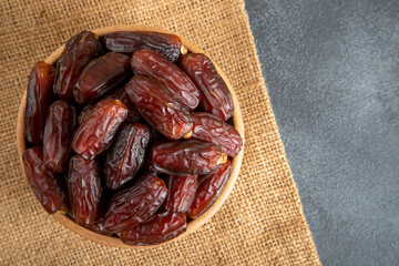 Date fruits in wooden bowl,top view