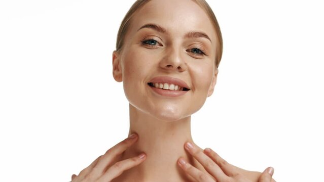 Beauty woman face with blue eyes looking at camera, isolated on white background. Beautiful female model with perfect clean fresh skin. Skin care treatment or cosmetic ads concept.