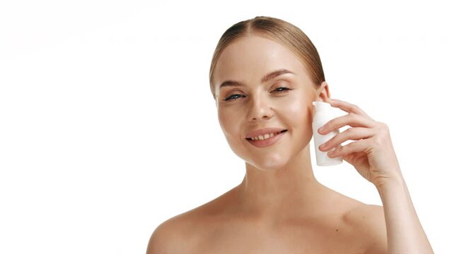 Slow motion portrait young woman uses creams of her face. Concept for fresh moisturized skin beautiful closeup cosmetic face happy healthy model. Young blonde hair woman take care of her skin