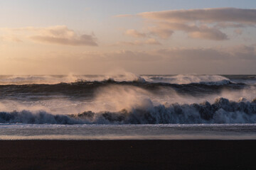 Black beach Iceland big ocean waves during sunrise