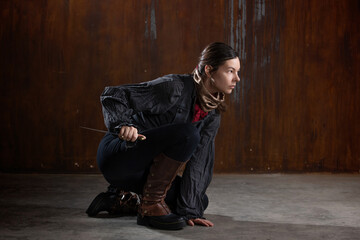 noble robber with a dagger in a squat, preparing to attack. A woman in a retro fantasy outfit on...