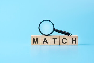 wooden blocks with the text: match with magnifying glass. business concept