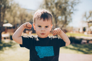 toddler boy showing his muscles