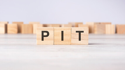 PIT - word concept written on wooden cubes or blocks on a light background
