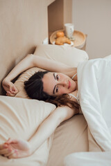 Obraz na płótnie Canvas Serene woman stretching arms after good sleep on bed