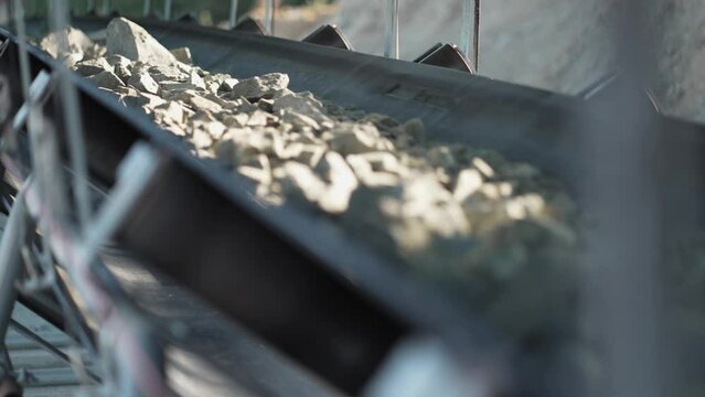 Industrial mining handling conveyor belt moving raw materials to production plant, slow motion, cinematic dof