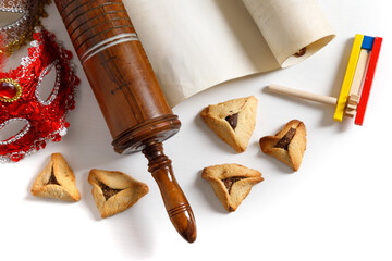 The Scroll of Esther and Purim Festival objects (rattles, masquerade mask, Hamantaschen) on white background. Top view