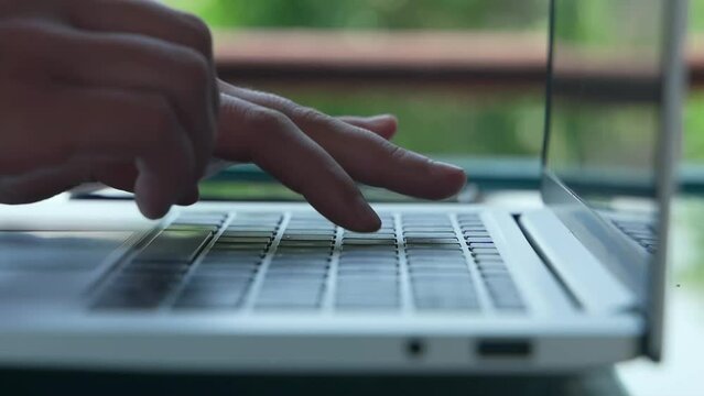 Close-up of ladies' hands that fluently type on a laptop while pressing hard