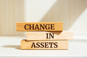 Wooden blocks with words 'CHANGE IN ASSETS'.