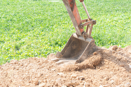 Close up of mini digger bucket excavating the ground.