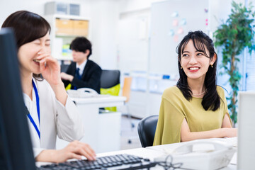 Fototapeta premium 楽しく話をしながらデスクワークをする女性