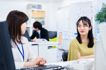 Fototapeta premium 楽しく話をしながらデスクワークをする女性