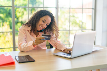 Latin woman working with hand holding card on working space