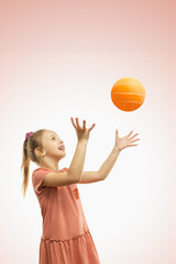 A cute happy girl throwing a ball.